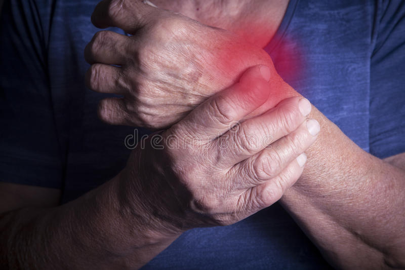 man with arthritis holding wrist