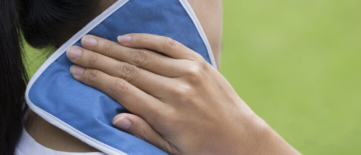 woman putting an ice pack on her neck pain